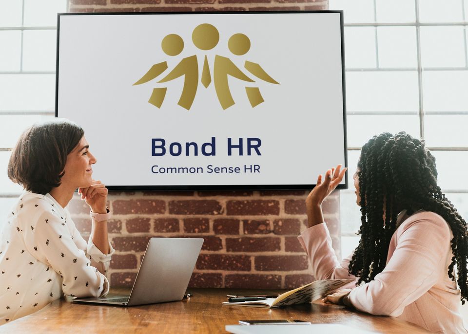 Bond HR branded meeting space with two people discussing business